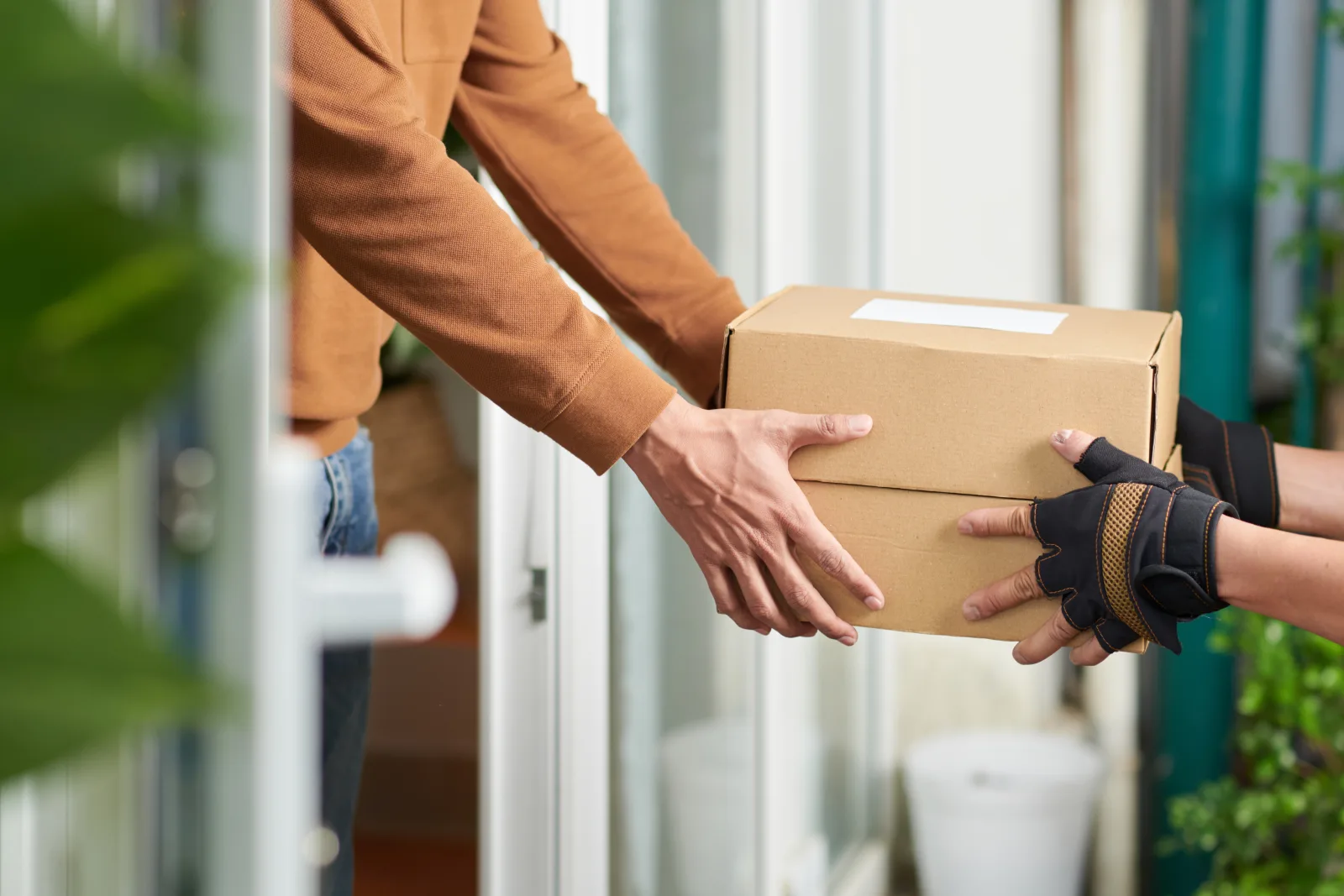 Courier handing a parcel to a patient at their front door