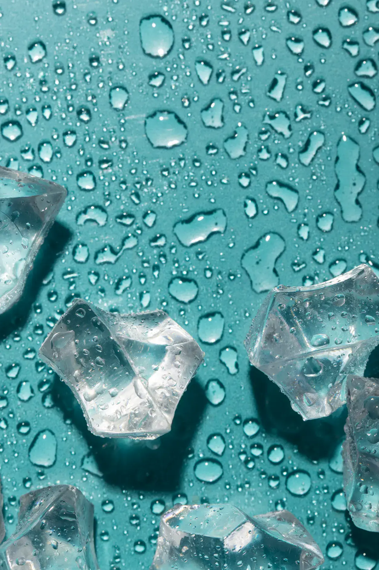 Ice melting on a teal surface